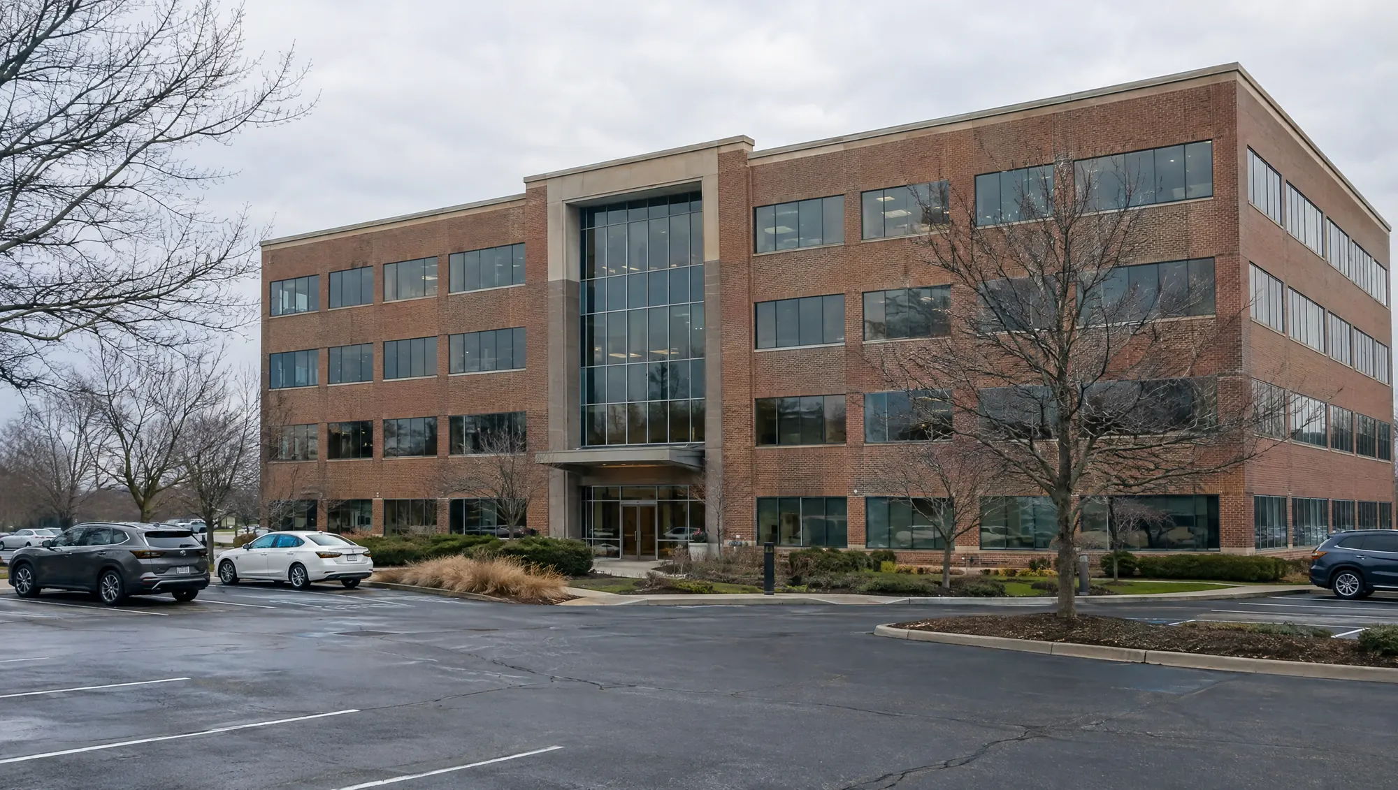 An ordinary four-story suburban office building on an overcast morning