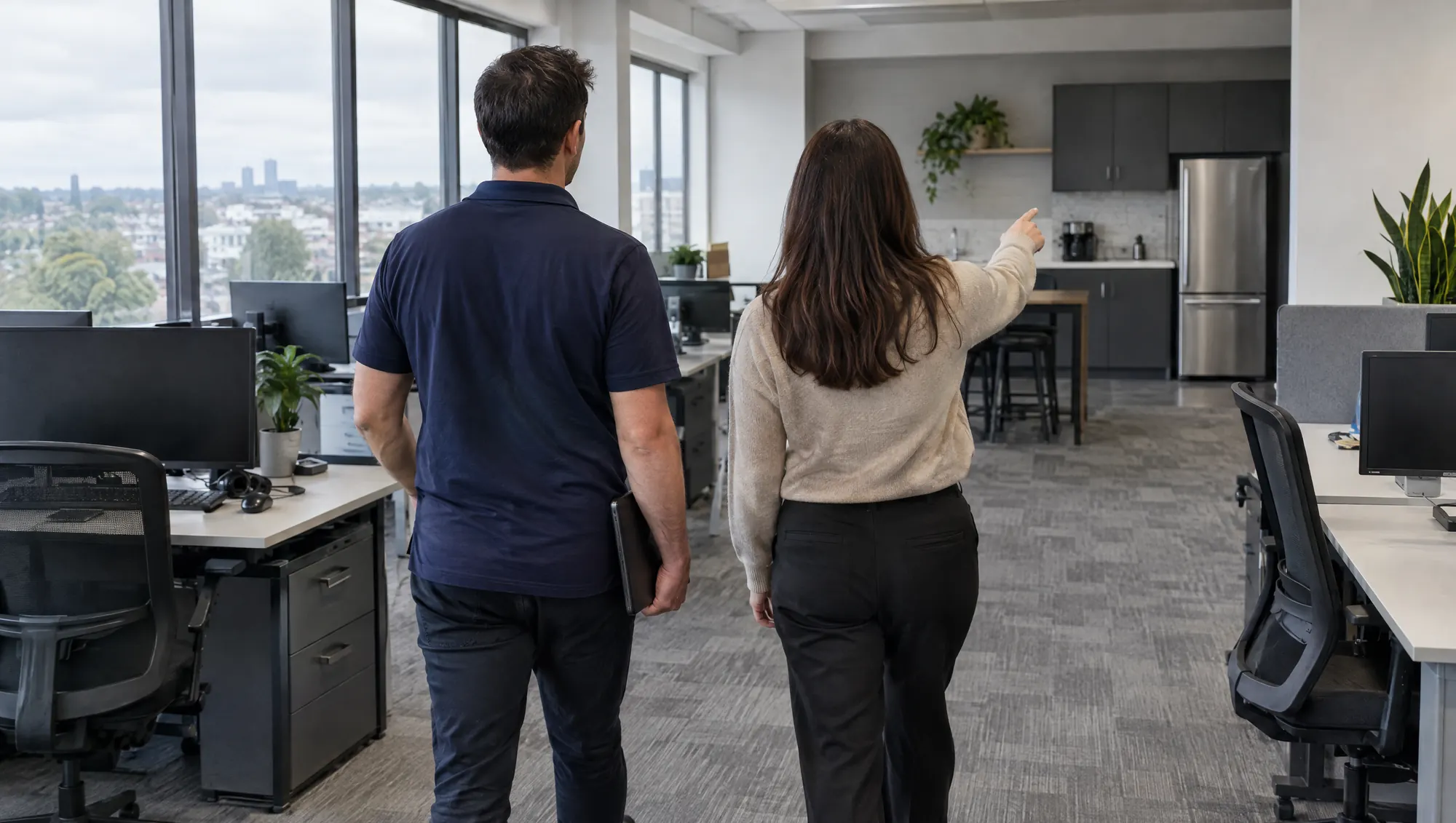 A site lead with a tablet and an office manager walking through an office before a quote